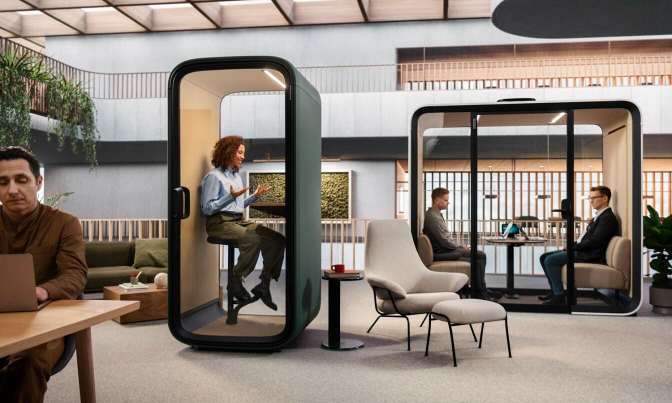 People working in an office with Framery Four and green Framery One Compact soundproof office pods.