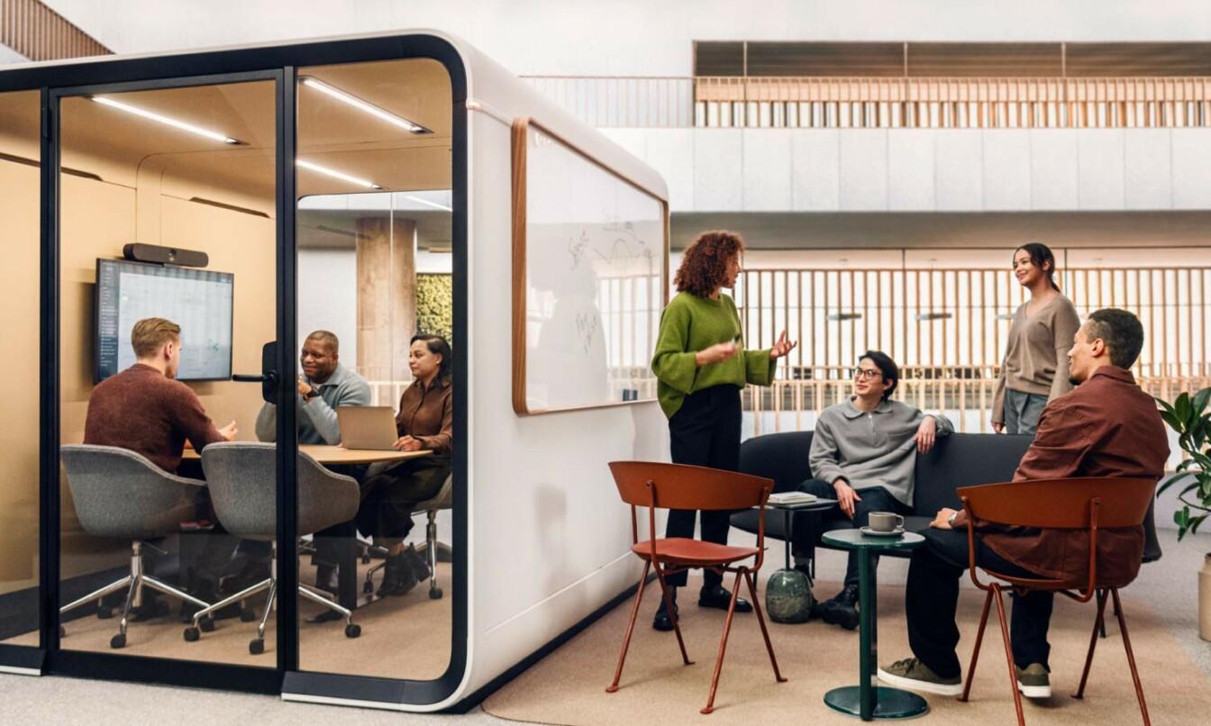 People having a meeting inside and outside a soundproof office meeting room Framery Six